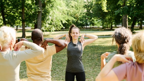 Health and wellness coach leading group exercise outdoors
